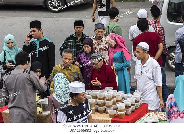 Vendor selling cakes in front Kuching City Centre mosque, Sarawak, Malaysia