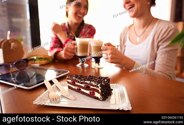 Ladies having round or cheers with cups of latte. Toned image of best friends meetig or date in cafe or restaurant