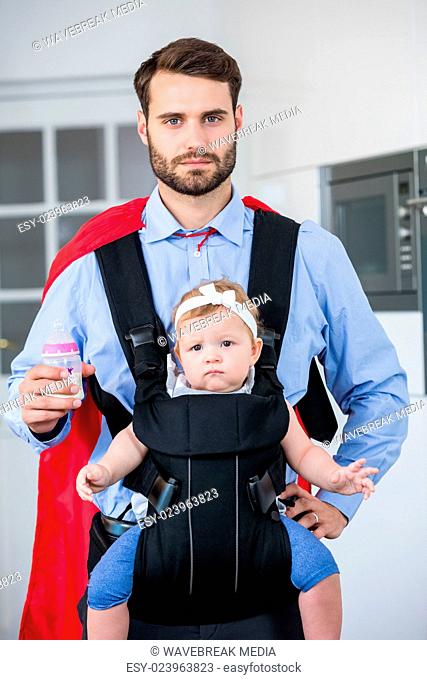 Man in superhero costume carrying daughter