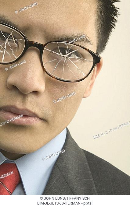 Young businessman with broken eyeglasses