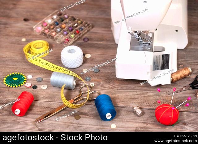Seamstress or tailor background with sewing tools, colorful threads, sewing machine and accesories