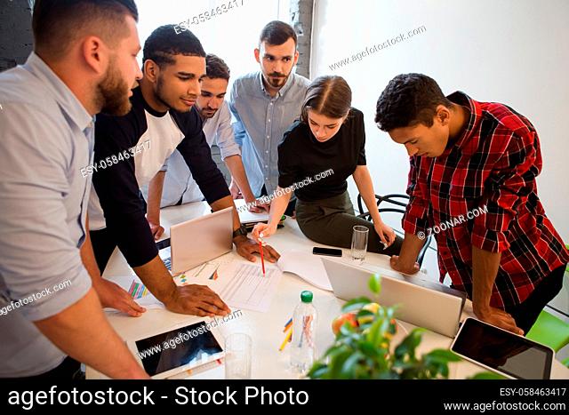 Picture of serious and executive office workers doing their job on board room in officeinterior. Business people working round table in office