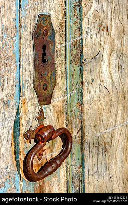 Old and aged historic wooden church door in the city of Ouro Preto, Minas Gerais with its rusty metal part