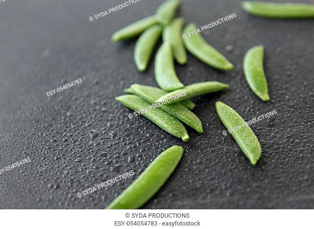 peas on wet slate stone background