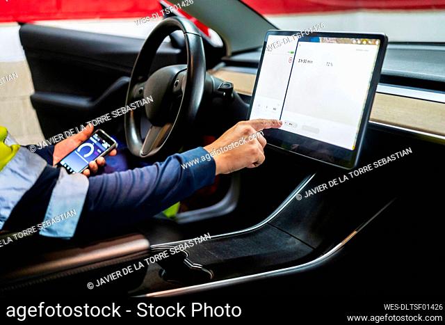Mature male programmer using digital tablet in car