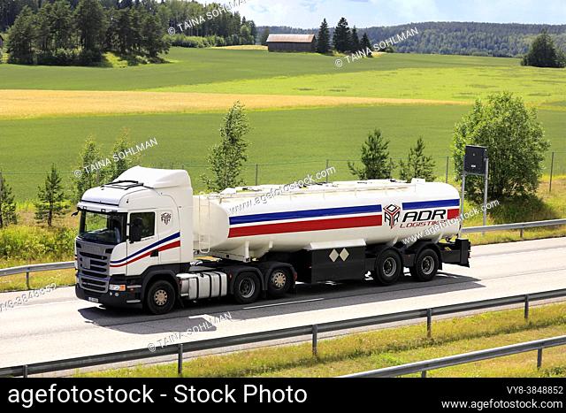 White Scania R450 semi tank truck ADR Logistica at speed on Finnish National Road 1. Salo, Finland