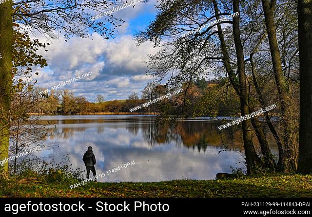 26 November 2023, Brandenburg, Falkenhagen: Clouds are reflected in the mill pond in the fall. Photo: Patrick Pleul/dpa. - Falkenhagen/Brandenburg/Germany
