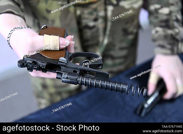 RUSSIA, SEVEROMORSK - MARCH 3, 2023: A girl assembles a rifle during a training at the Avangard Centre for Military Patriotic Education of the Youth at the...