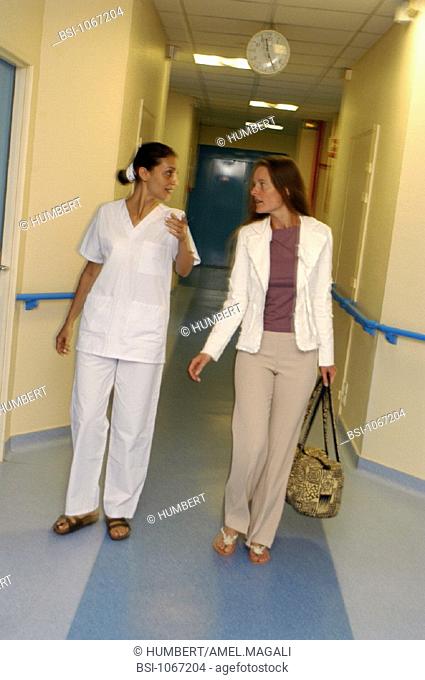 WOMAN HOSPITAL PATIENT WITH NURSE<BR>Models.<BR>Hospital check-in or check-out