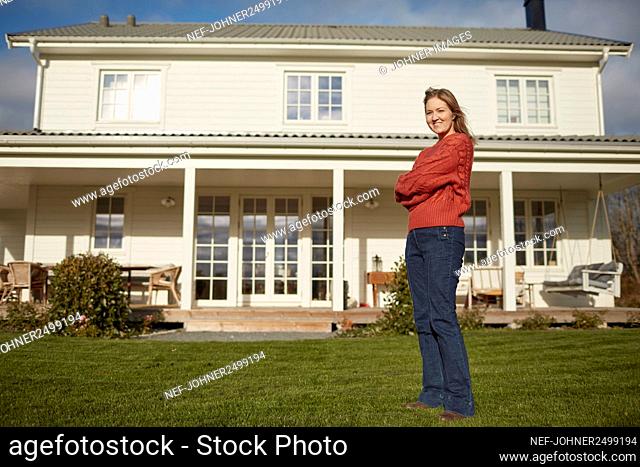 Young woman standing in front of house