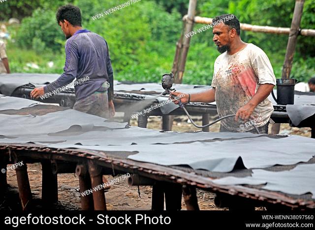 Workers from Hazaribagh are seen painting leather and putting pieces out to dry as part of the finish process of leather tanning in a small factory to sell it...