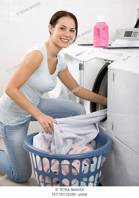 Woman talking laundry out of dryer