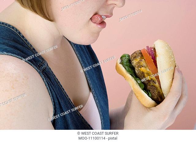 Mid-adult woman holding hamburger