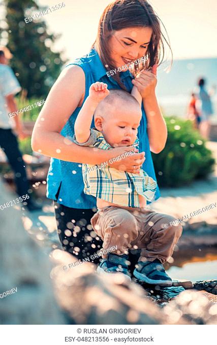 happy mother and toddler son near the fountain
