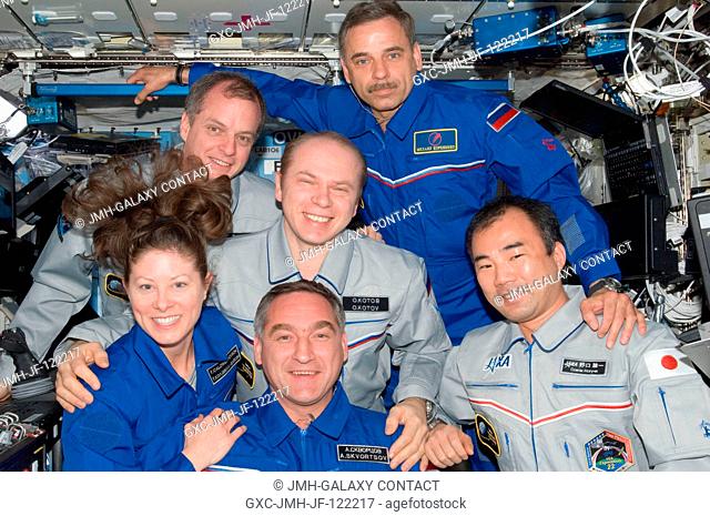 Expedition 23 crew members pose for a in-flight crew portrait in the Destiny laboratory of the International Space Station while space shuttle Discovery...