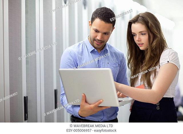Two technicians looking at laptop in data center
