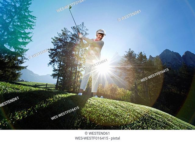Italy, Kastelruth, Mature woman playing golf on golf course