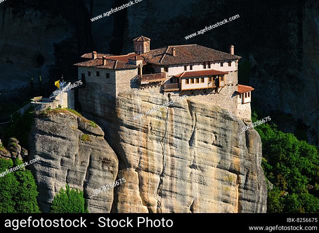 Monastery of Rousanou perched on a cliff in famous greek tourist destination Meteora in Greece on sunset with scenic landscape