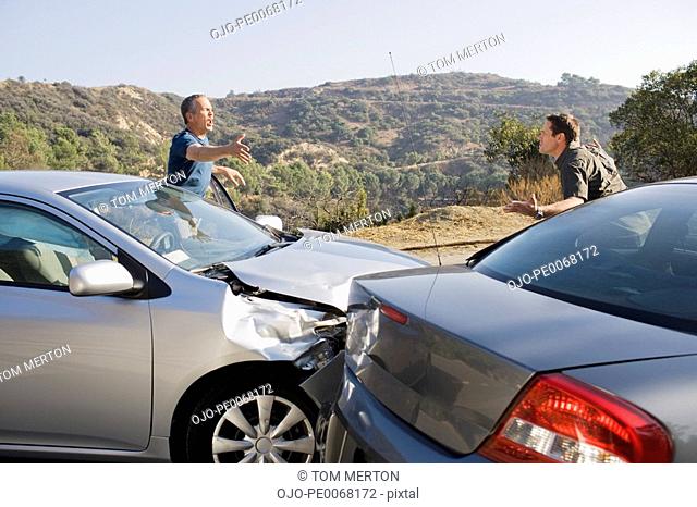 Two men arguing about damaged cars