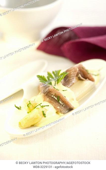 Platillo de esparragos blancos y filetes de anchoas con salsa de mantequilla