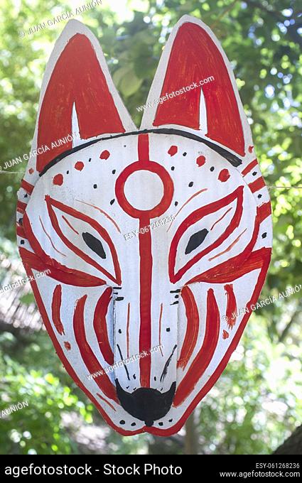 Carboard Kitsune mask hanging on rope. Japanesse culture craft workshop concept