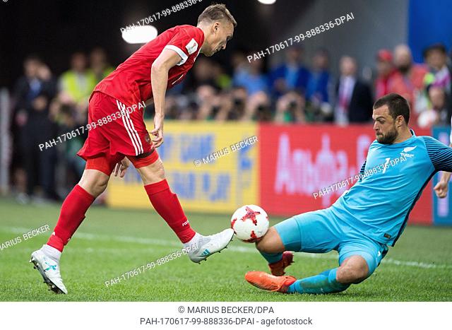 New Zealand goalie Stefan Marinovic (r) blocks a ball from Russia's Aleksandr Burharov during the Confederations Cup Group A soccer match between Russia and New...