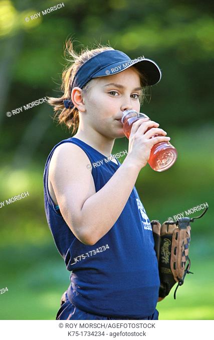 Young girl drinks sports drink to keep hydrated