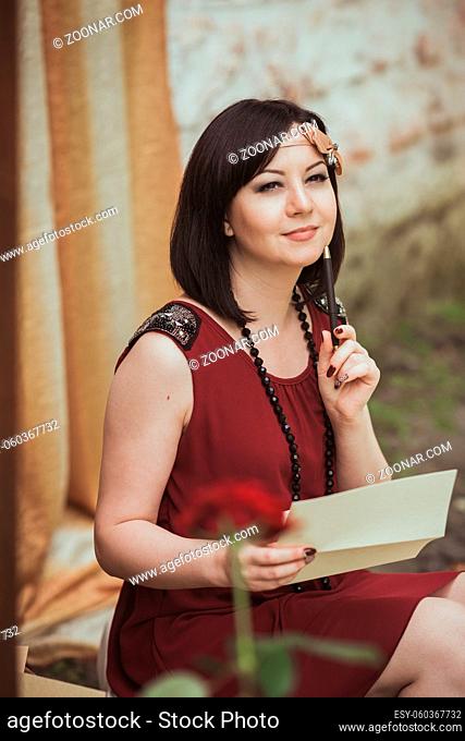 Portrait of a girl in a retro style that sits with letter in your hands