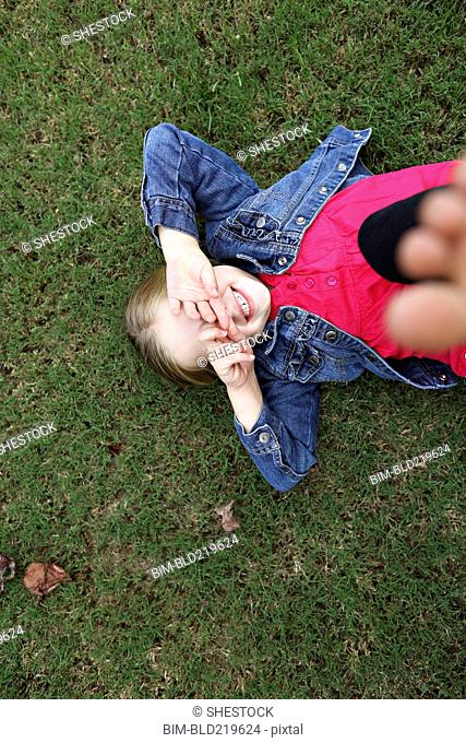 High angle view of girl laying in grass