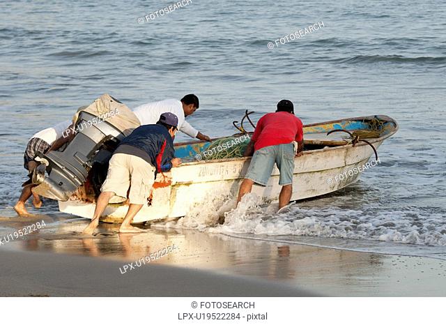People pushing a boat into the sea, Sayulita, Nayarit, Mexico