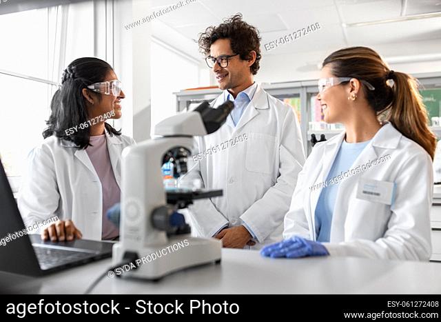 scientists with microscope working in laboratory