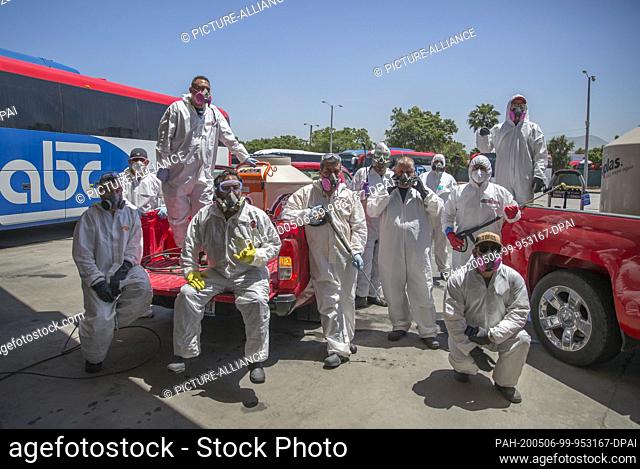 02 May 2020, Mexico, Tijuana: Members of the ""Covid Busters"" group stand in protective suits next to the cars with which they drive through the city and carry...