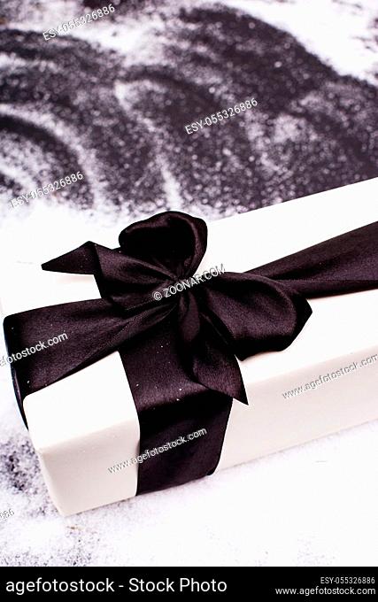 Gift with black ribbon and snow