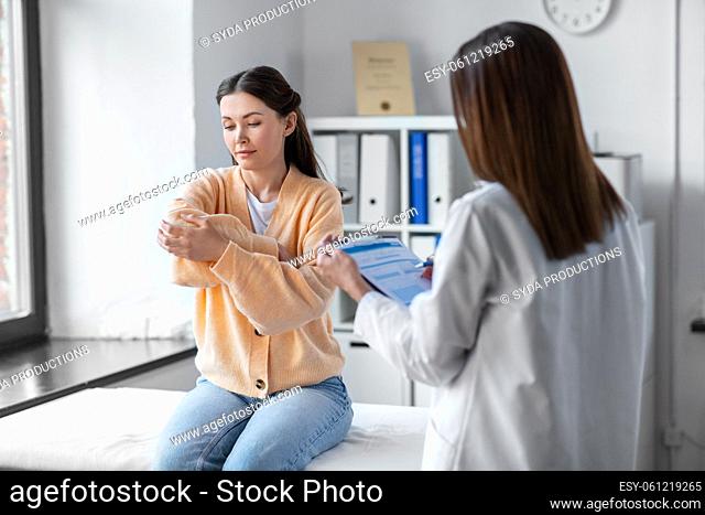 female doctor and woman with sore arm at hospital