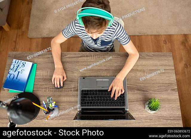 boy in headphones using laptop at home