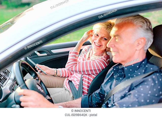 Happy tourist couple driving car