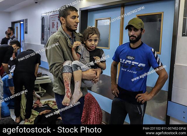 GRAPHICS - 02 November 2023, Palestinian Territories, Gaza City: A Palestinian brings a wounded girl to Al-Shifa Hospital