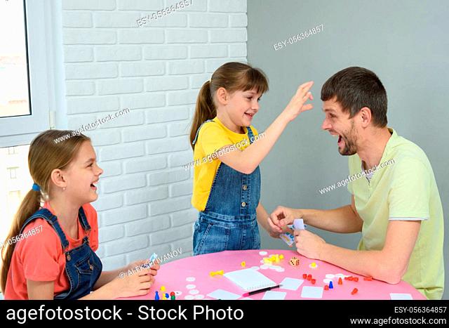 Daughter is going to punch dad in the forehead for a loss in a board game
