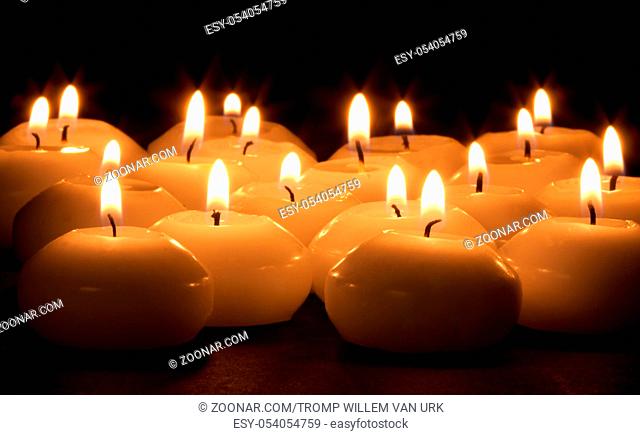 Group of burning candles at a black background