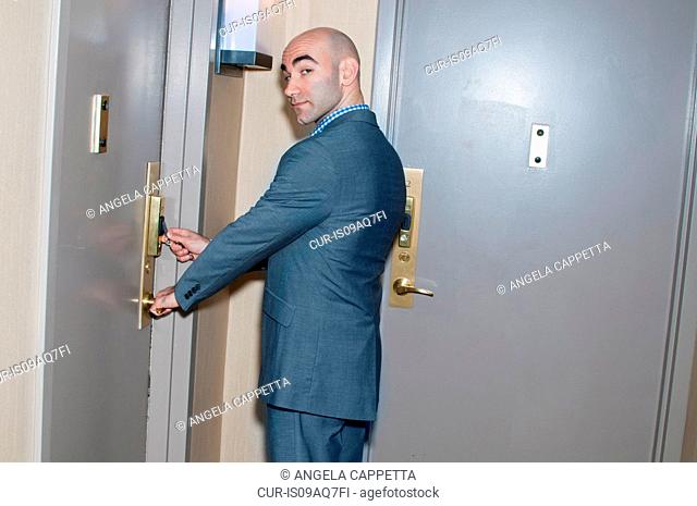 Young businessman unlocking electronic locked door