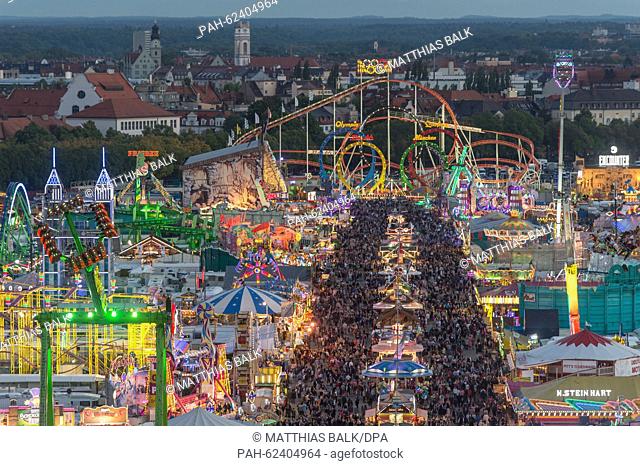 At dusk numerous visitors can be seen on the Theresienwiese, the grounds of Oktoberfest, in Munich,  Germany, 02 October 2015