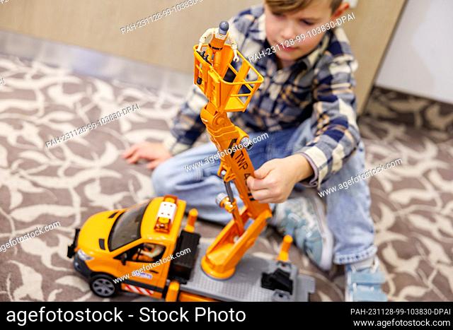 28 November 2023, Bavaria, Nuremberg: Six-year-old Henri plays with the ""MB Sprinter work platform"" from toy manufacturer Bruder on the fringes of the annual...