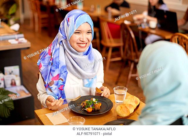 Young South-east Asian women eating at restaurant