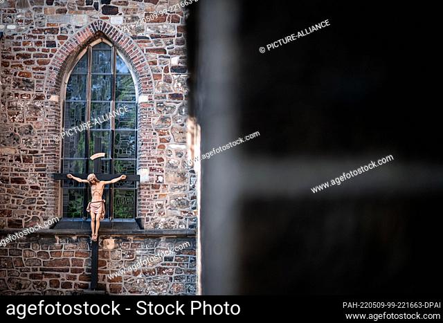 09 May 2022, North Rhine-Westphalia, Datteln: A statue of Jesus hangs on the outside facade of the church. The St. Amandus Parish Council holds a blessing...