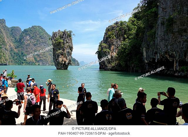 06 March 2019, Thailand, Khao Phing Kan: Tourists take pictures on the beach of the island Khao Phing Kan in front of the striking rock Khao Ta-Pu