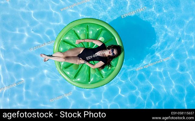 A brunette model in a swimming pool environment