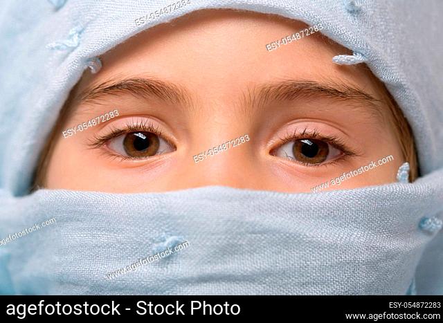 young girl with a veil covering her, close up, studio picture