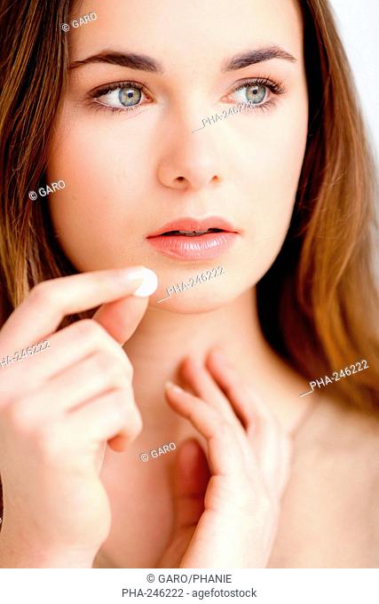 Woman taking potassium iodide used to saturate the thyroid with nonradioactive iodine when using compounds containing radioactive iodine in nuclear medicine and...