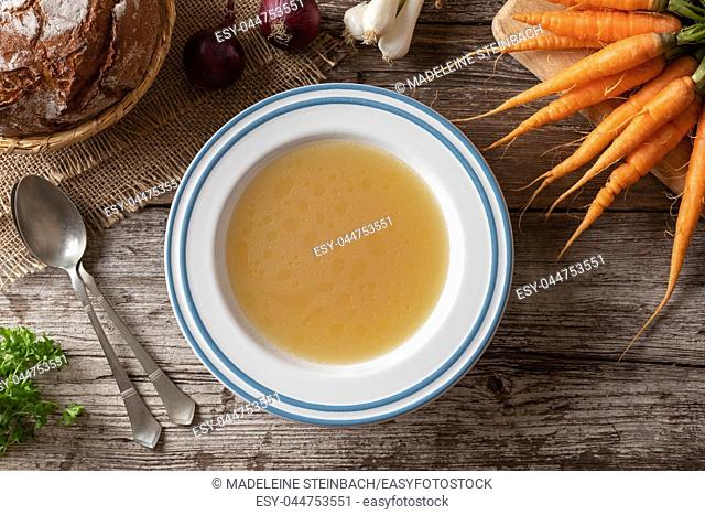 Chicken bone broth with fresh vegetables, top view