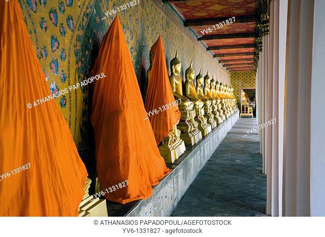 Symetrical Golden Buddha Statues On A Row Wearing Orange Buddhist Ribbons While The First Three Are Covered With Orange Cloths At Wat Arun Temple Also Known As...